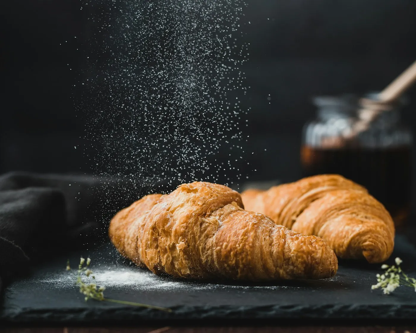 Golden croissants with a dusting of sugar; illustrative stock photograph